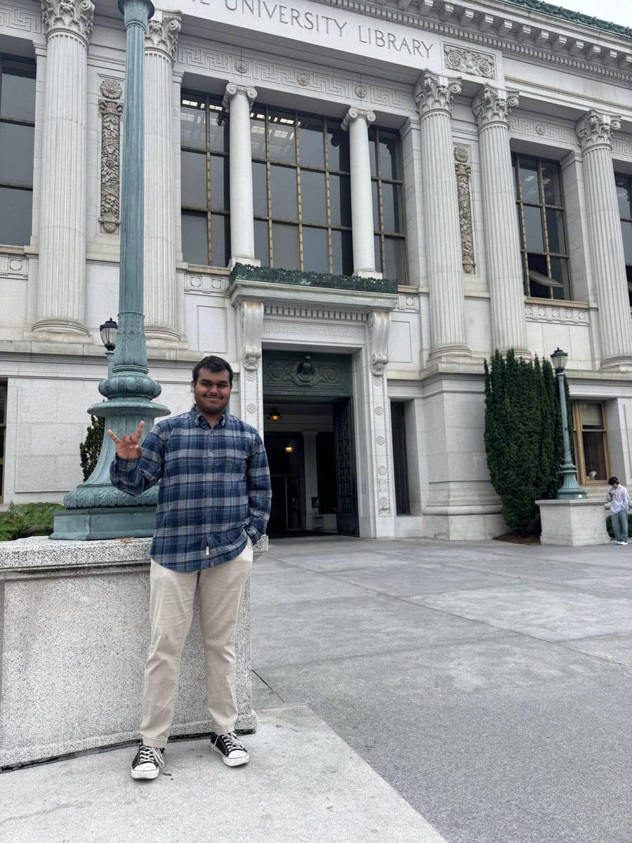 Vishanth throwing up the Hook em sign outside the UC Berkeley library