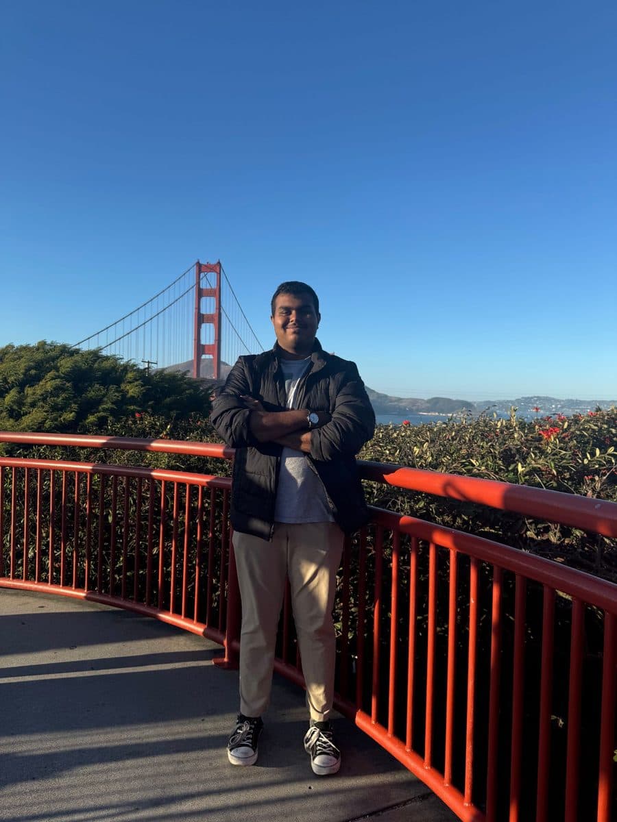 Vishanth at a red railing with the Golden Gate Bridge behind him